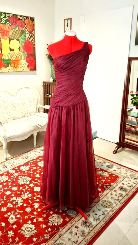 Vestido largo granate con escote asimétrico y cuerpo drapeado