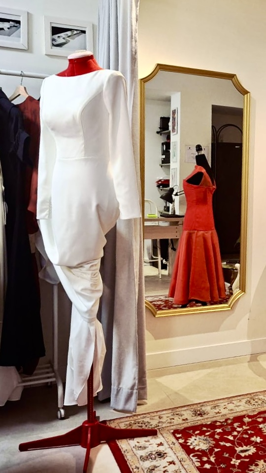 Vestido blanco de manga larga con drapeado en la falda
