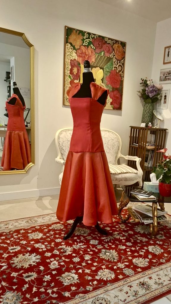 Vestido de fiesta en tonos rojo y naranja sobre un maniquí