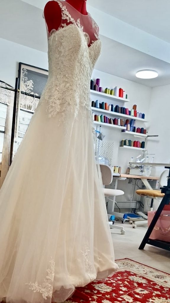 Vestido de novia con cuerpo de encaje y falda larga sobre un maniquí